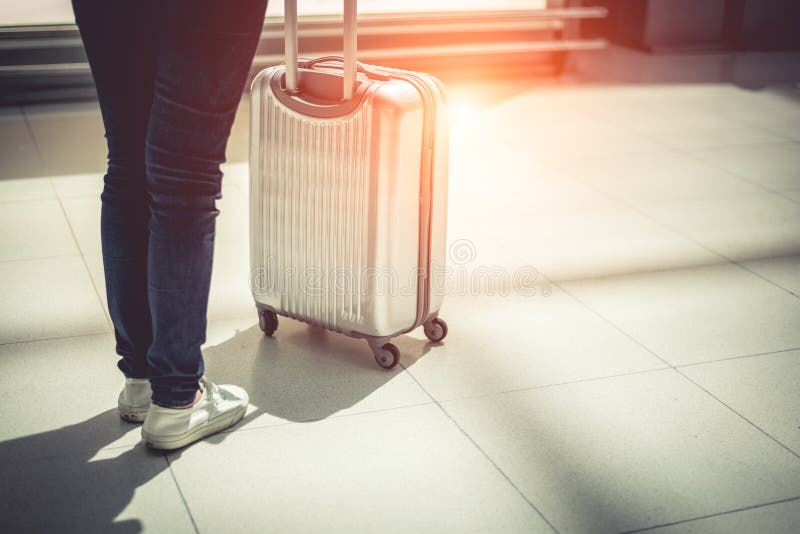 Close up woman and suitcase trolley luggage in airport. People a