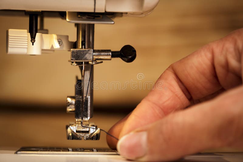 Closeup of a Woman Threading the Needle of a Sewing Machine. the