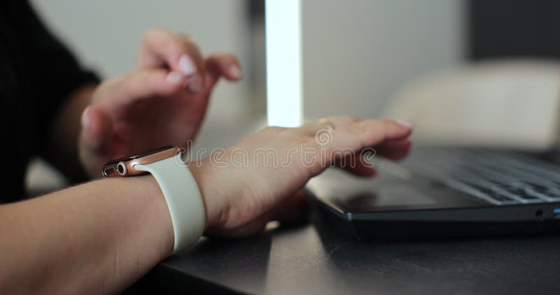 Close-up of woman touching smart watch screen swiping device display in office. Young woman using smart watch. stock footage