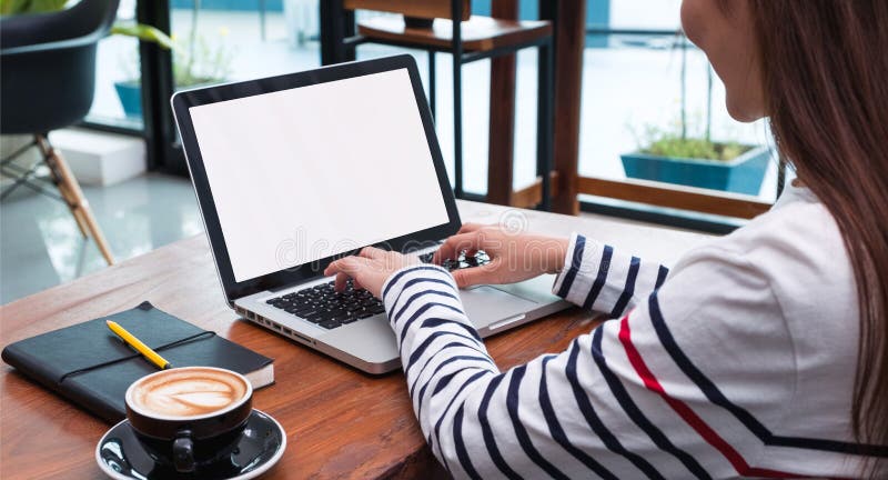 Close up woman type on laptop keyboard and looking at computer screen on table in coffee shop,Blank notebook screen mock up for stock images