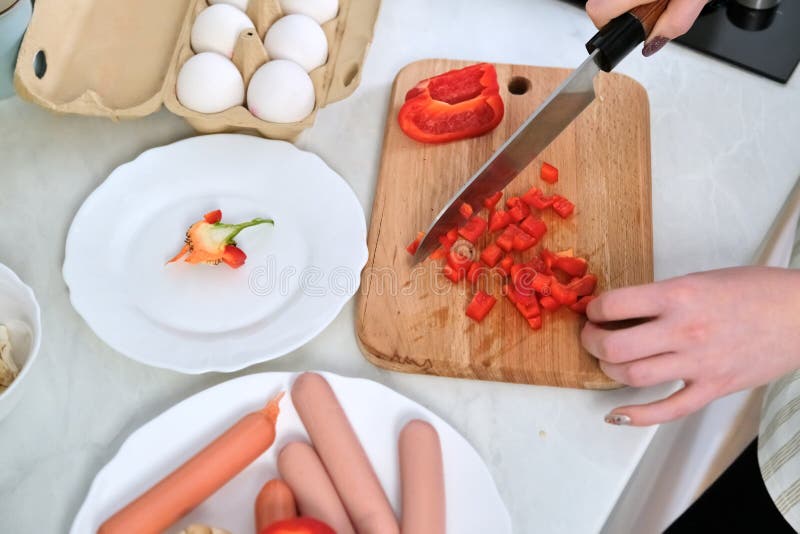 Close-up of womans hands cooking food in the kitchen, cutting paprika with knife stock photography Close-up of womans hands cooking food in the kitchen, cutting paprika with knife stock photography