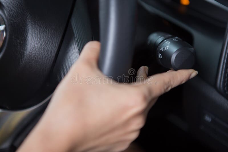 Women`s hand is adjusting headlights