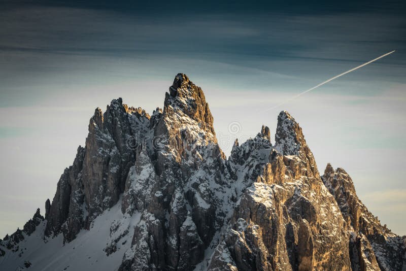 Close up of wonderful snowy rocky mountain range peaks in dolomites, in sunset and blue sky, italy