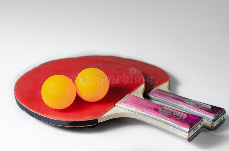 Close-up of  wood   red  ping pong paddles  and  yellow     plastic  balls. Physical activity that can be done at home during the