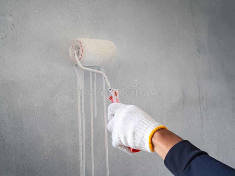 Close up of worker hand useing roller and brush for painting wall. House building concept stock images Close up of worker hand useing roller and brush for painting wall. House building concept stock images