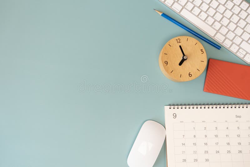 Workspace desk with clock, notebook, calendar, computer keyboard green background with copy space, minimal style, for stock photo