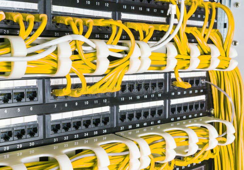 Zblízka žlutou sítě internet kabely, patch kabely připojené k černé switch, router v datovém centru.