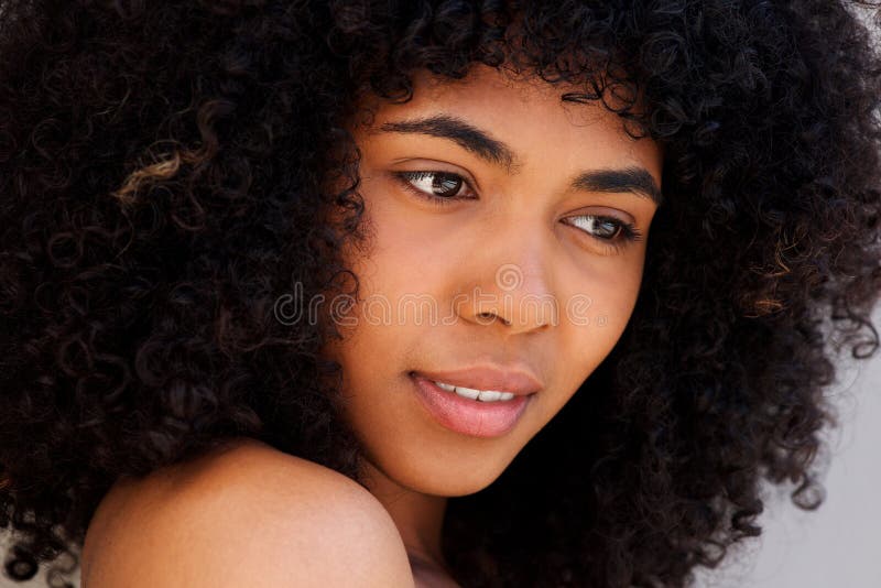 Close up beautiful young african american woman with curly hair looking away