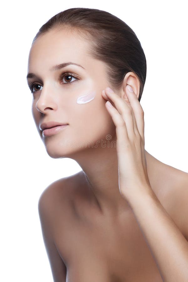 Close-up young beautiful face of girl applying moisturize cream