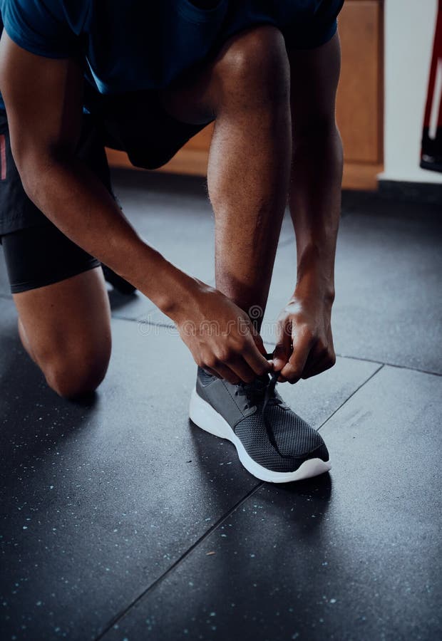 Close-up of Young Black Man Tying Shoelace of Shoe at the Gym Stock ...