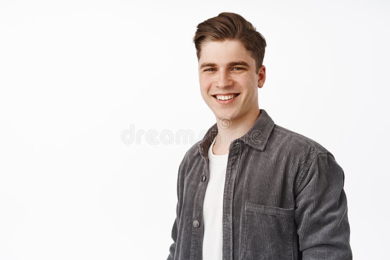 Close up of young candid guy, handsome man smiling white teeth, standing relaxed and casual against isolated studio