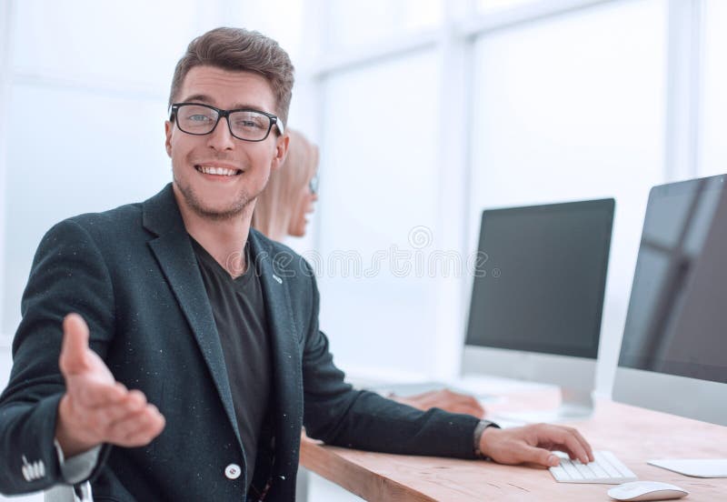 Young employee sitting at his Desk in the office stock photo Young employee sitting at his Desk in the office stock photo