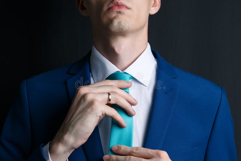 Close-up young man in an suit. He is in a white shirt with a tie. The man straightens his tie, his face unshaven royalty free stock photos Close-up young man in an suit. He is in a white shirt with a tie. The man straightens his tie, his face unshaven royalty free stock photos