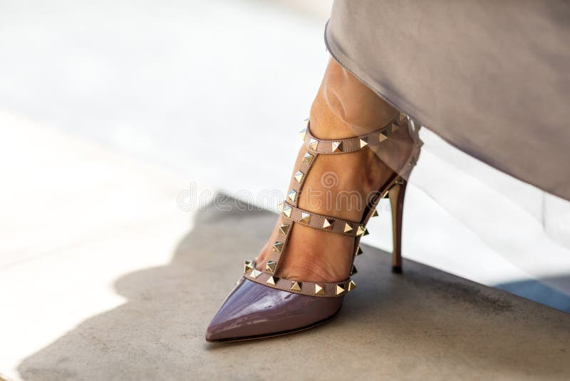 Close-up of young woman`s legs in high-heeled shoes