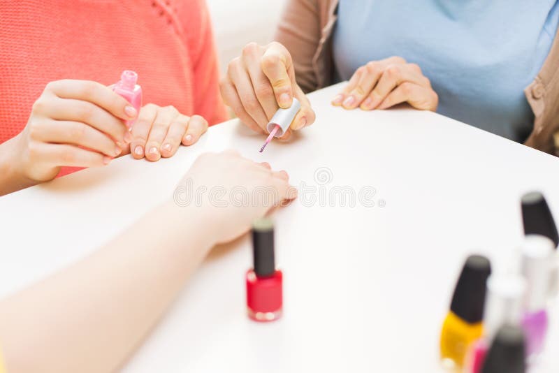 close up young women nail polish beauty make manicure cosmetics people concept teenage girls painting nails 67651335