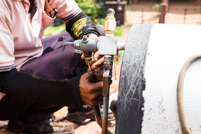 Close-uparbeider die zonnewaterverwarmer op dak bevestigen tijdens maintena royalty-vrije stock foto Close-uparbeider die zonnewaterverwarmer op dak bevestigen tijdens maintena royalty-vrije stock foto