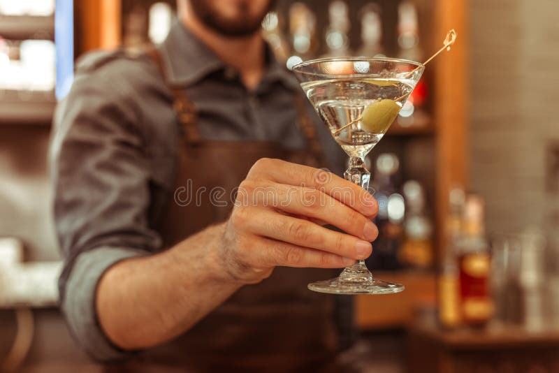 Close-upfoto van bararbeider die een martini-cocktail houden royalty-vrije stock afbeeldingen Close-upfoto van bararbeider die een martini-cocktail houden royalty-vrije stock afbeeldingen