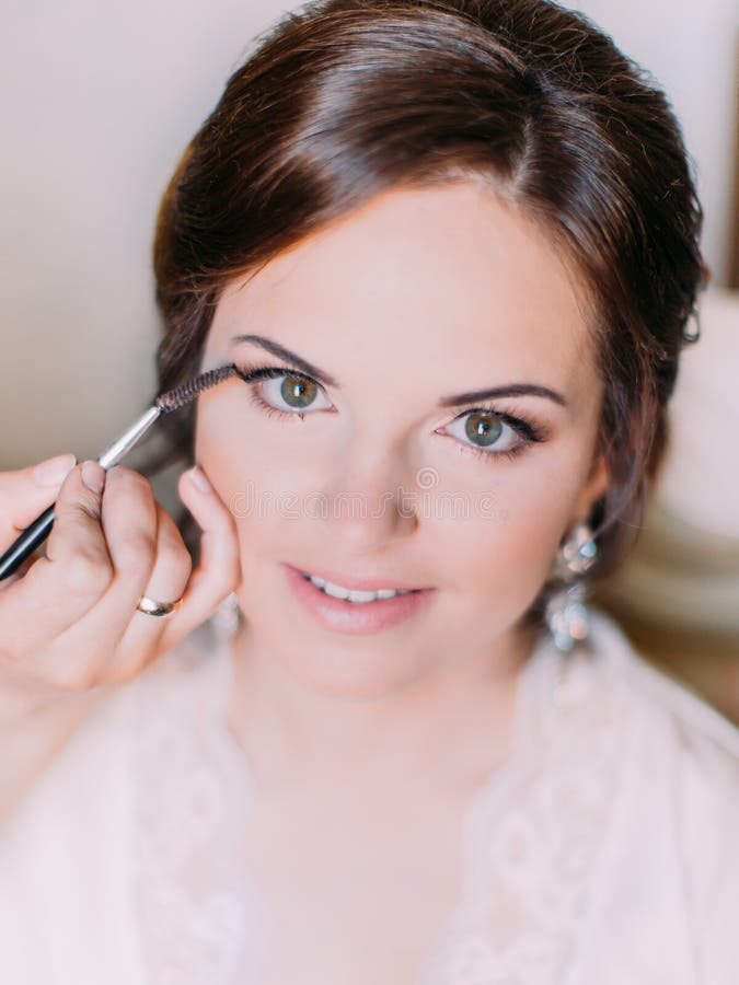 Close-upmening van de hand van de make-upkunstenaar die de make-up voor de bruid doen royalty-vrije stock foto's Close-upmening van de hand van de make-upkunstenaar die de make-up voor de bruid doen royalty-vrije stock foto's