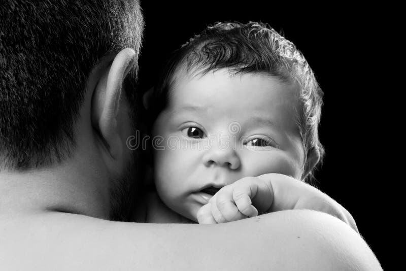 Close-upportret van een pasgeboren baby in de schouder van de papa Het kind van de vaderholding op een zwarte achtergrond stock afbeeldingen Close-upportret van een pasgeboren baby in de schouder van de papa Het kind van de vaderholding op een zwarte achtergrond stock afbeeldingen
