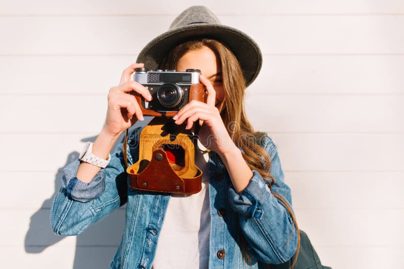 Close-upportret van het charmeren van vrouwelijke fotograaf die nieuwe foto's buiten met oude professionele camera maken Jong bru stock fotografie Close-upportret van het charmeren van vrouwelijke fotograaf die nieuwe foto's buiten met oude professionele camera maken Jong bru stock fotografie