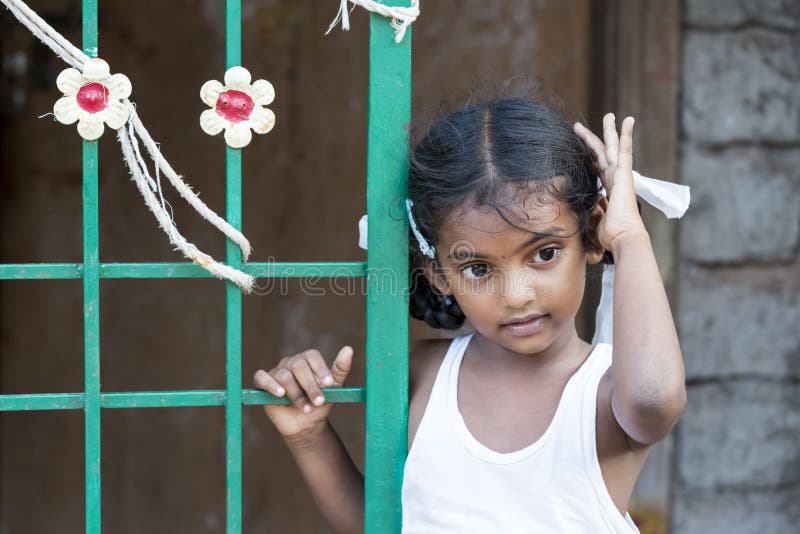 PONDICHERY, PUDUCHERRY, TAMIL NADU, INDIA - March circa, 2018. Closeup portrait of unidentified shy timid young pretty Indian girl child looking away and playing with her hair. Shy concept. PONDICHERY, PUDUCHERRY, TAMIL NADU, INDIA - March circa, 2018. Closeup portrait of unidentified shy timid young pretty Indian girl child looking away and playing with her hair. Shy concept.