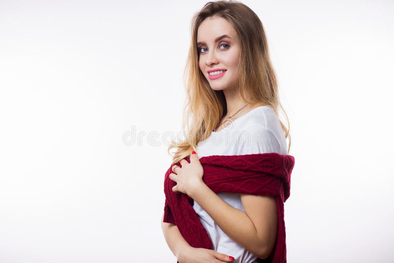 Close-upportret van mooie jonge blondevrouw in witte t-shirt en rode sweater op witte achtergrond royalty-vrije stock foto Close-upportret van mooie jonge blondevrouw in witte t-shirt en rode sweater op witte achtergrond royalty-vrije stock foto