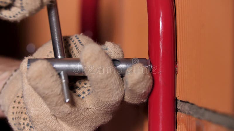 Close view of a male worker using hex wrench for wall works. Stock footage. Master trying to attach metal detail to the