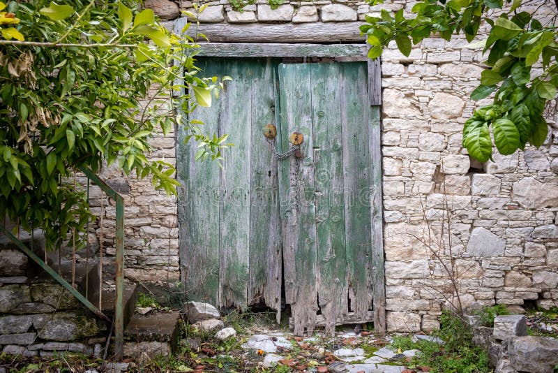 Closed green wooden old vintage door on a stoned wall. Closed green wooden old vintage door on a stoned wall.