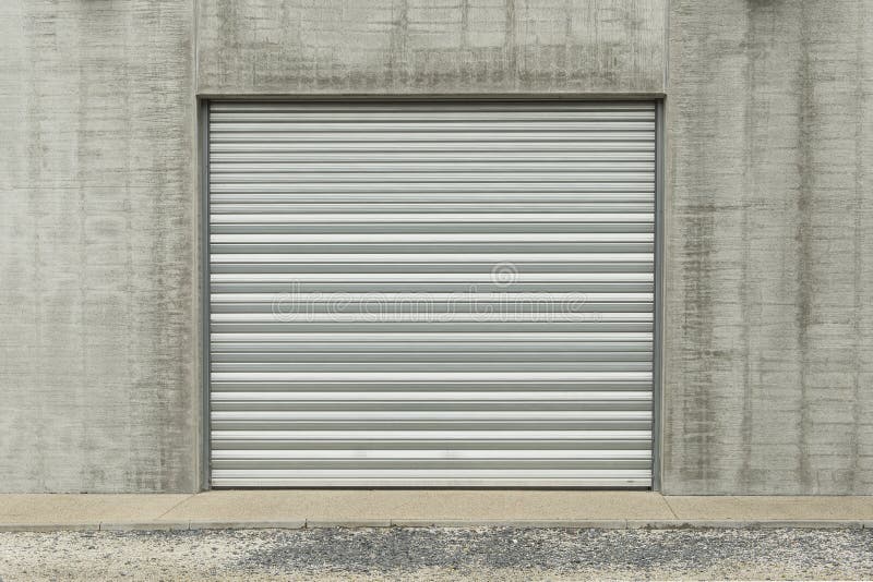 Metallic garage door in a grey industial wall royalty free stock images