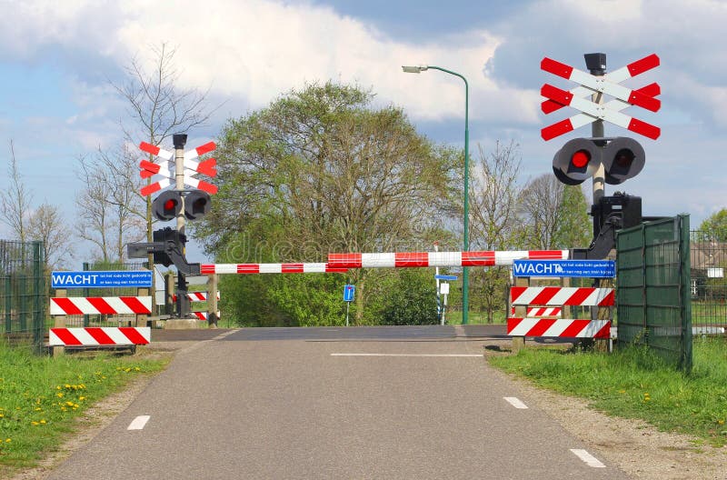 Closed railroad barriers at a rural railway crossing in the polder, Netherlands