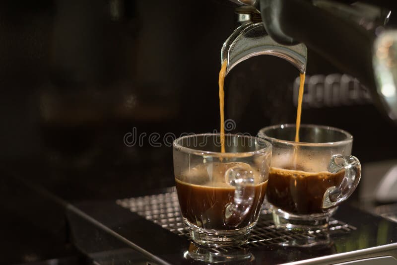 Close-up of espresso machine and shot glasses during a pour Stock