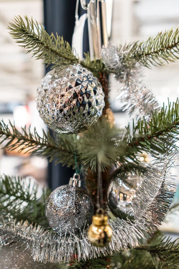 Closed up hanging shiny patterned silver ball, tinsel and ornaments on green christmas tree stock photo Closed up hanging shiny patterned silver ball, tinsel and ornaments on green christmas tree stock photo