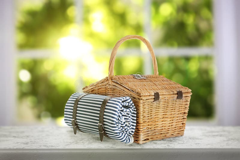 Closed Wicker Picnic Basket with Blanket on Stone Table Indoors Stock