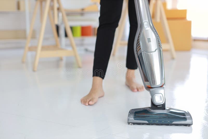 Closeup active housewife woman legs using vacuum cleaning floor with SME and E-commerce Package box background. stock images Closeup active housewife woman legs using vacuum cleaning floor with SME and E-commerce Package box background. stock images
