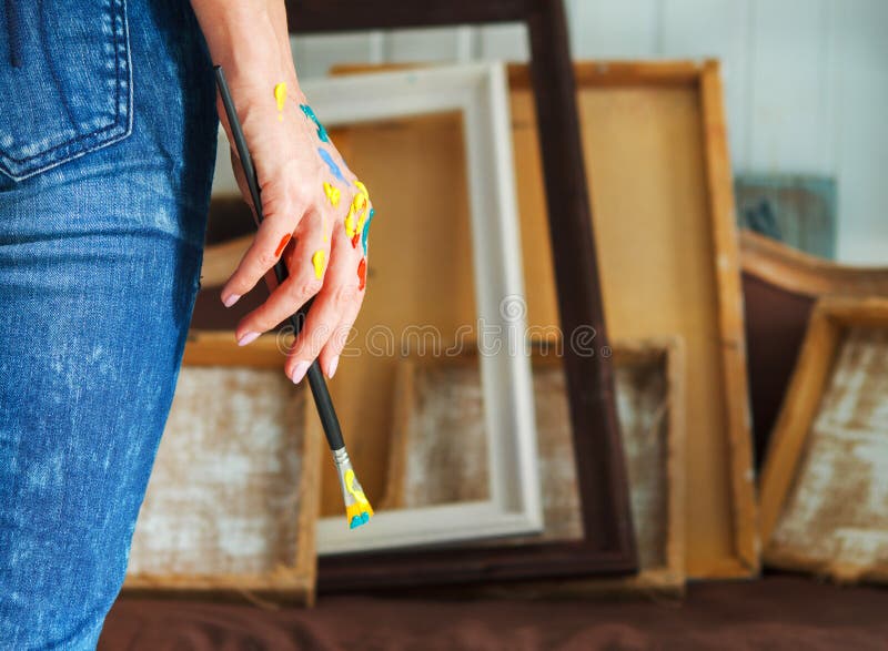 Closeup of an artist hand holding paintbrush