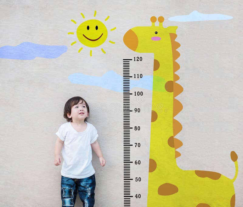 Closeup asian kid stand for measure height and look at cute giraffe cartoon at the marble stone wall textured background