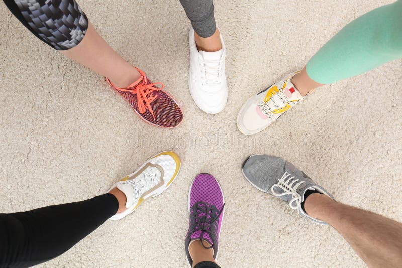 Closeup of athletes wearing sports shoes and standing in circle on beige carpet stock images Closeup of athletes wearing sports shoes and standing in circle on beige carpet stock images