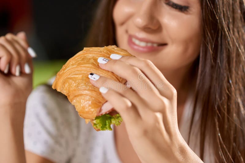 Closeup av den smakliga gifflet i händer av den nätta flickan royaltyfri fotografi Closeup av den smakliga gifflet i händer av den nätta flickan royaltyfri fotografi
