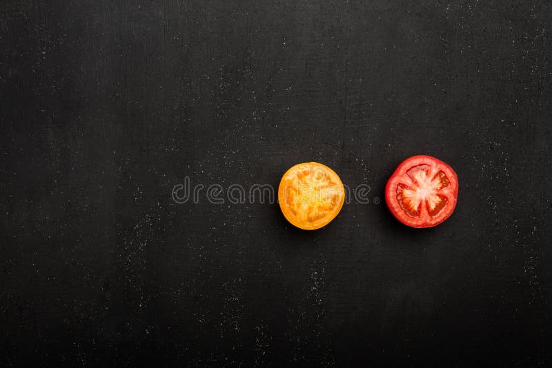 Closeup av det mogna saftiga röda och orange tomatsnittet i halva med på en stentabell arkivfoto Closeup av det mogna saftiga röda och orange tomatsnittet i halva med på en stentabell arkivfoto
