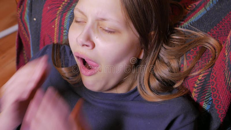 Closeup av en olyckligt tonårigt flicka, sammanträde och gäspa 4k UHD