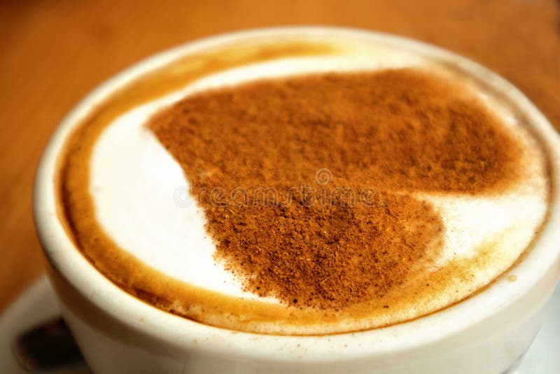 Closeup av en stor vit kopp av varm kaffecappuccino med konstdesignhjärta på den som står på en träbakgrund, förälskelsebegrepp arkivbild Closeup av en stor vit kopp av varm kaffecappuccino med konstdesignhjärta på den som står på en träbakgrund, förälskelsebegrepp arkivbild