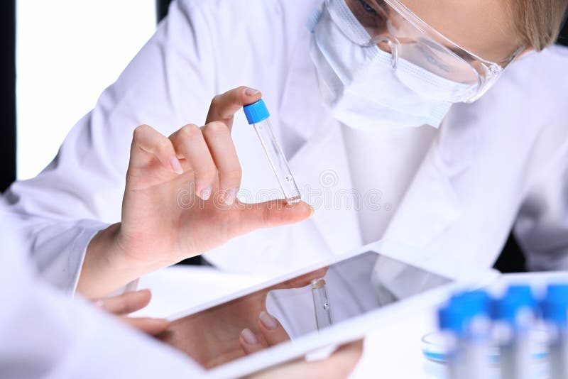 Closeup av laget för vetenskaplig forskning med den klara lösningen i laboratorium Den blonda kvinnliga kemisten rymmer provröret royaltyfri foto Closeup av laget för vetenskaplig forskning med den klara lösningen i laboratorium Den blonda kvinnliga kemisten rymmer provröret royaltyfri foto