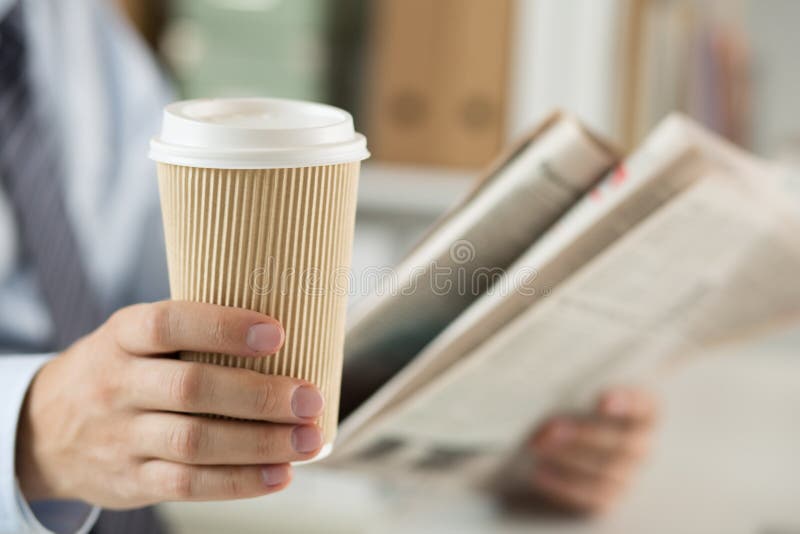 Closeup av läs- nyheterna för affärsman och den hållande kaffekoppen royaltyfria bilder Closeup av läs- nyheterna för affärsman och den hållande kaffekoppen royaltyfria bilder