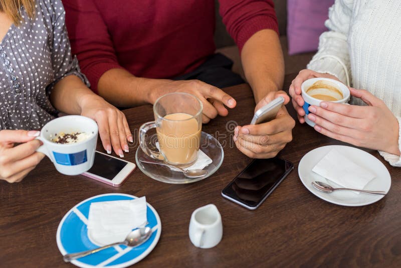 Closeup av vänner som har kaffe på ett kafé arkivbilder