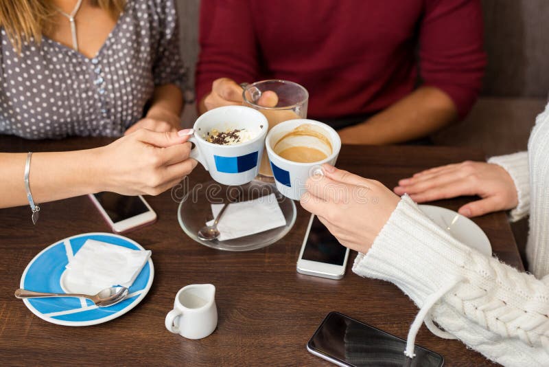 Closeup av vänner som har kaffe på ett kafé arkivfoton