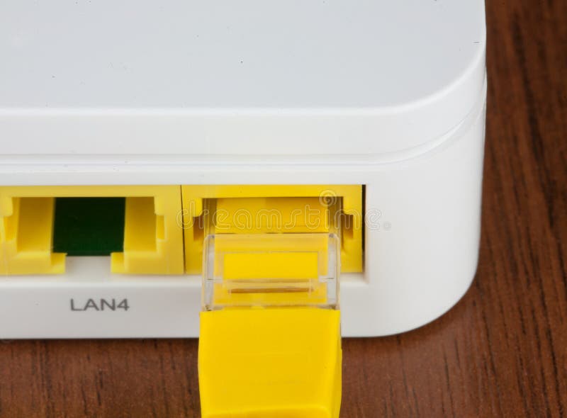Closeup back of white wifi router LAN port with UTP patch cord inside stock image