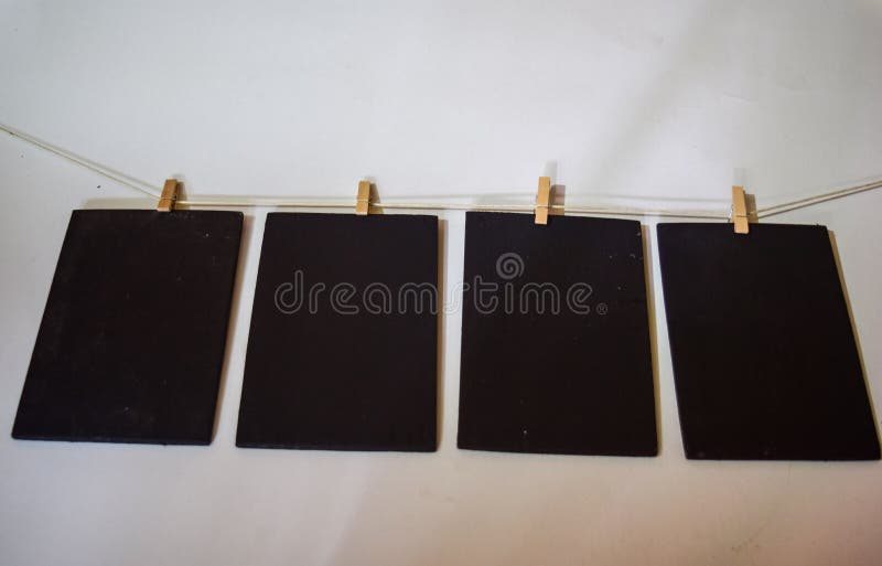 Closeup black paper attach to rope with clothes pins on white background stock photos Closeup black paper attach to rope with clothes pins on white background stock photos