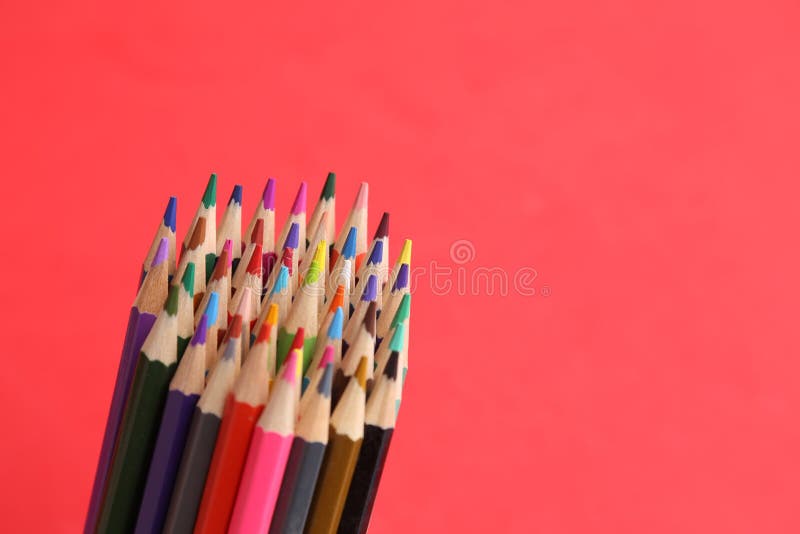Closeup of a bundle of colored pencils on a red background stock photos
