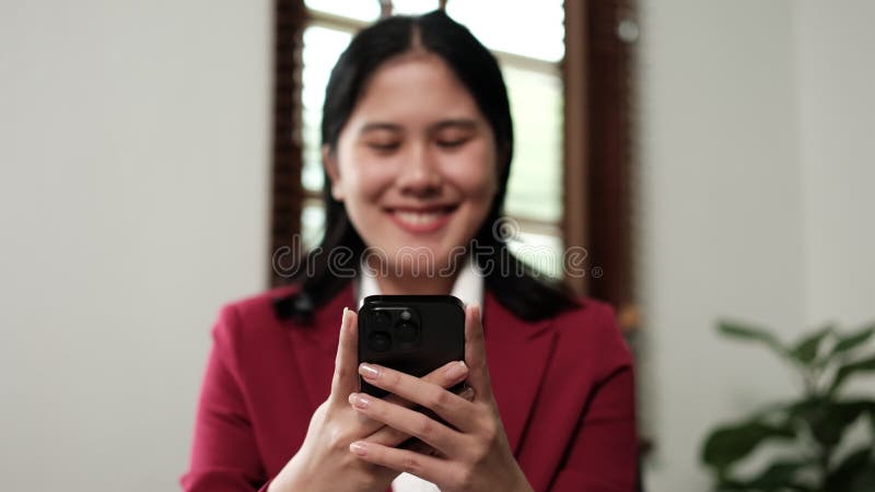 Femeie de afaceri care încheie mesaje de dactilografiere pe telefon mobil inteligent la birou, femeie de afaceri tânără care vorbe stock footage