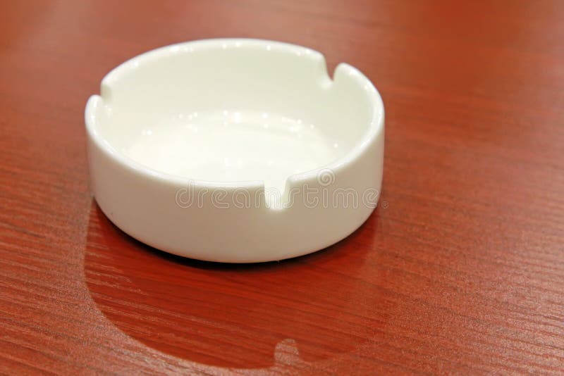 Ceramic ashtray on the red table